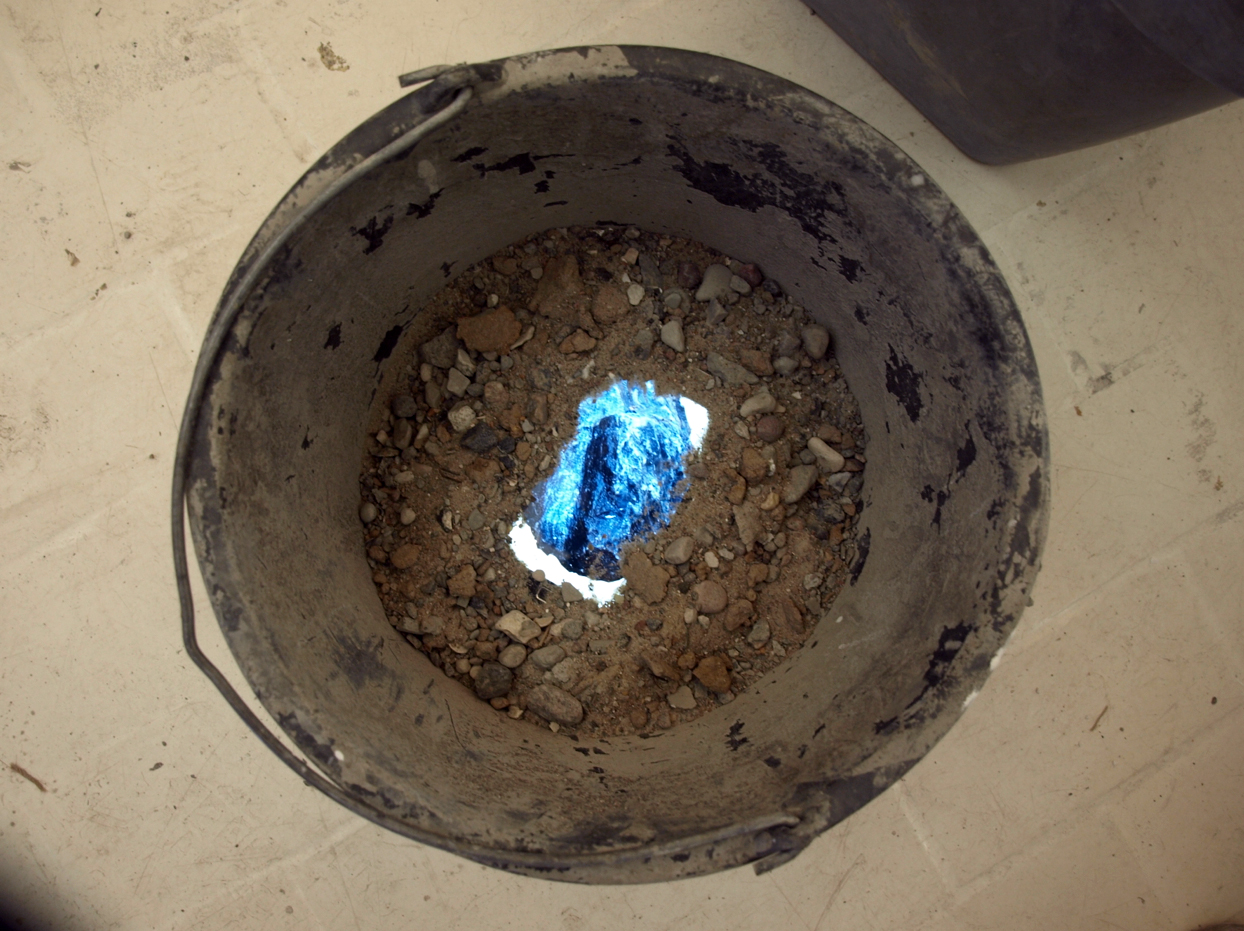 process picture: tablet showing rock picture, partly covered in earth