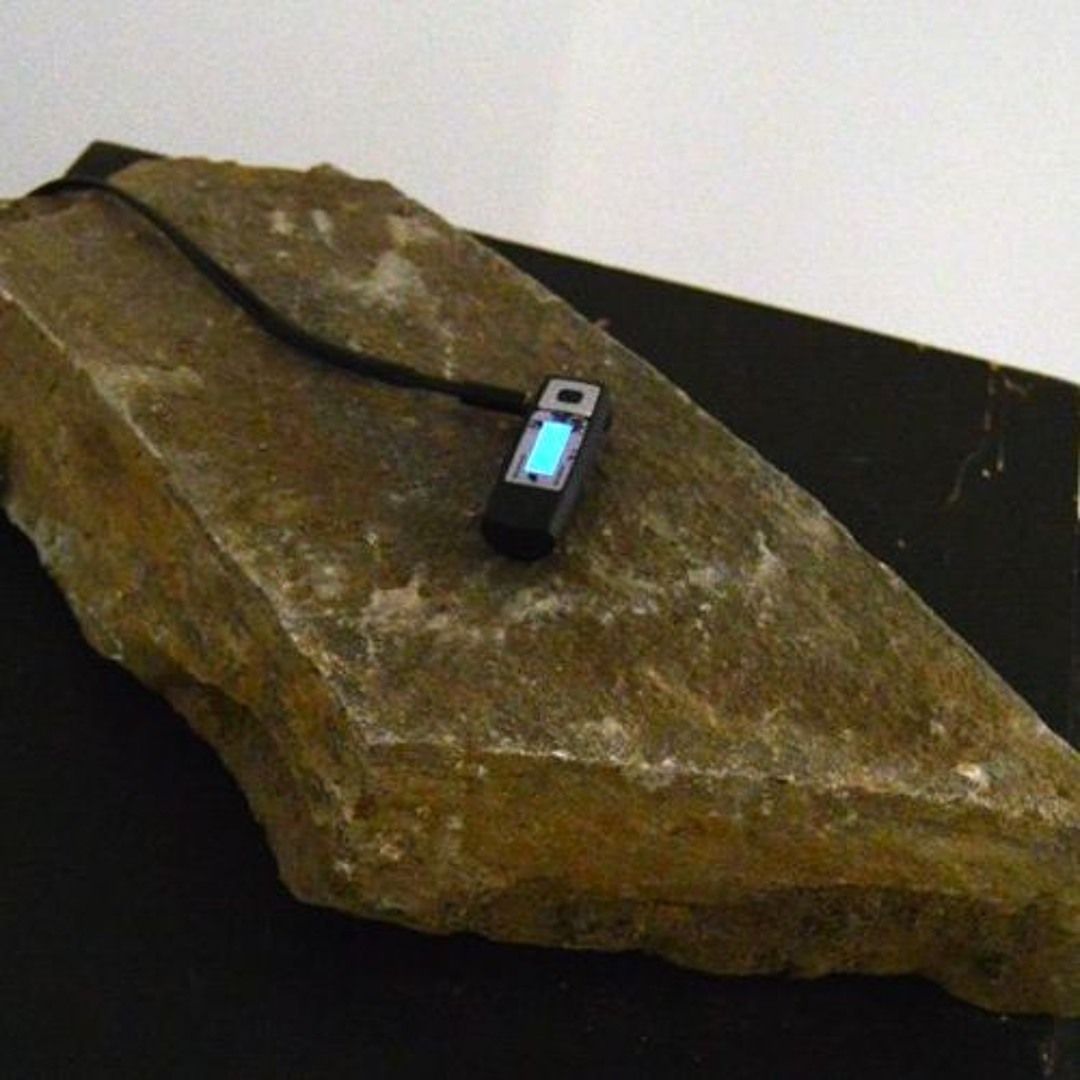 mp3 player placed on a rock on a piedestal